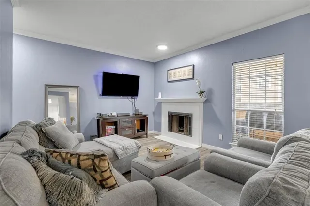 a living room with furniture a fireplace and a flat screen tv
