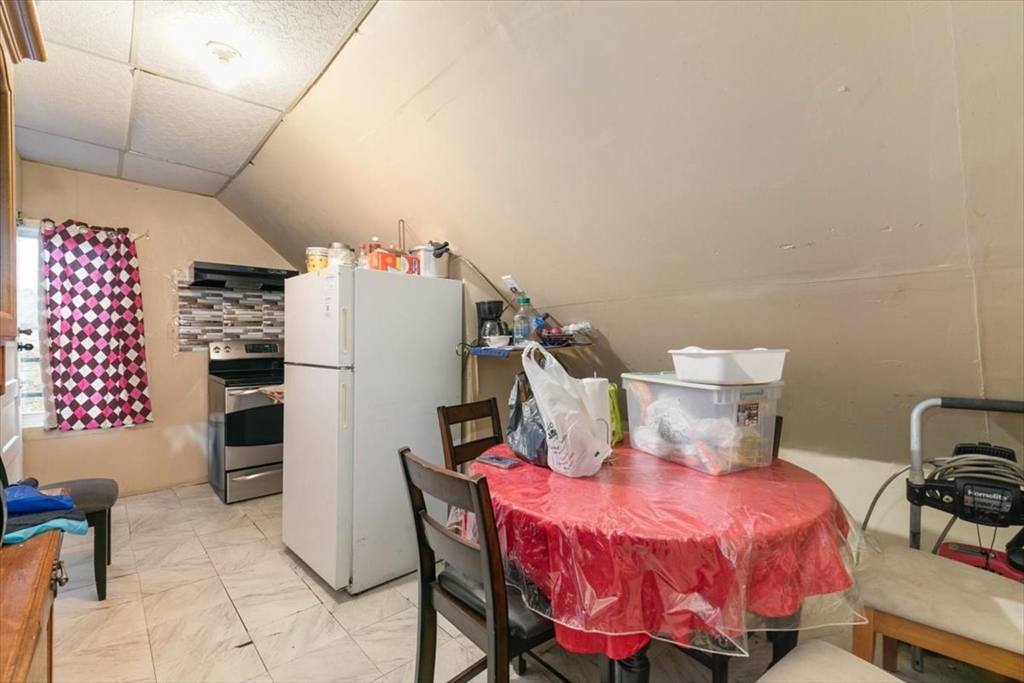 2 Washington Street Lawrence, MA 01841 - Photo 22 of 28 a bed room with a bed and a refrigerator