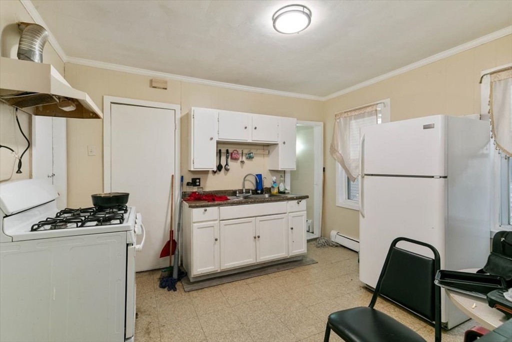 2 Washington Street Lawrence, MA 01841 - Photo 10 of 28 a kitchen with a refrigerator and a stove top oven