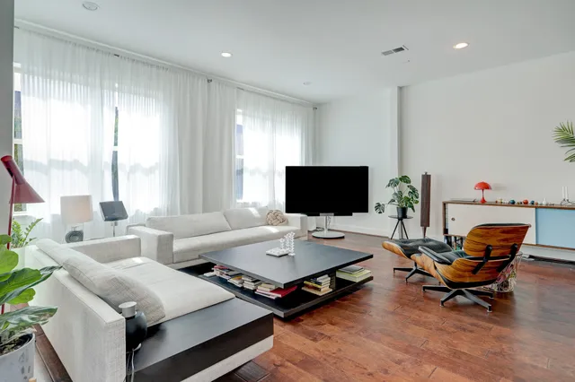 an empty room with wooden floor fireplace and windows