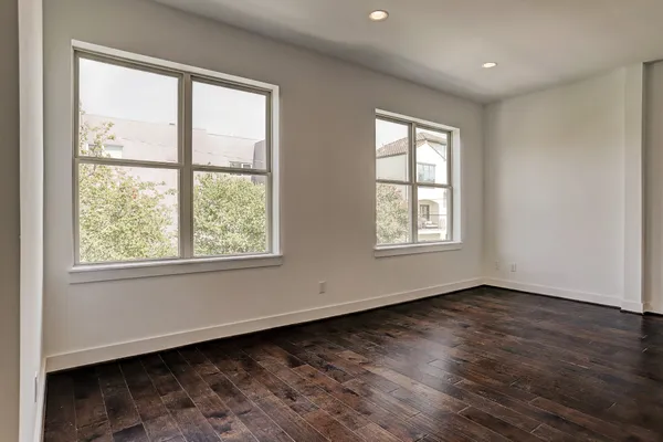 a view of empty room with wooden floor