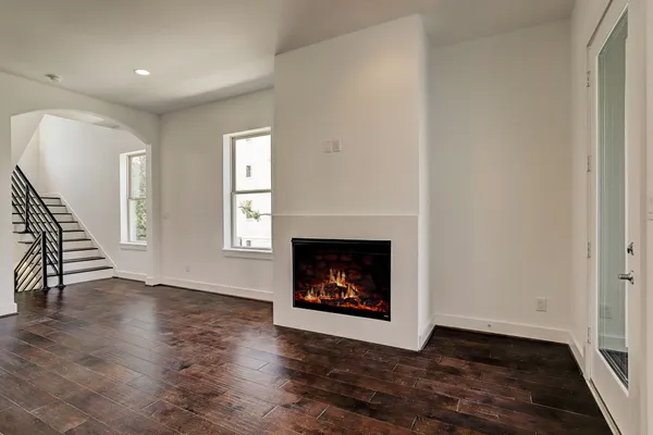 a view of kitchen and empty room with wooden floor