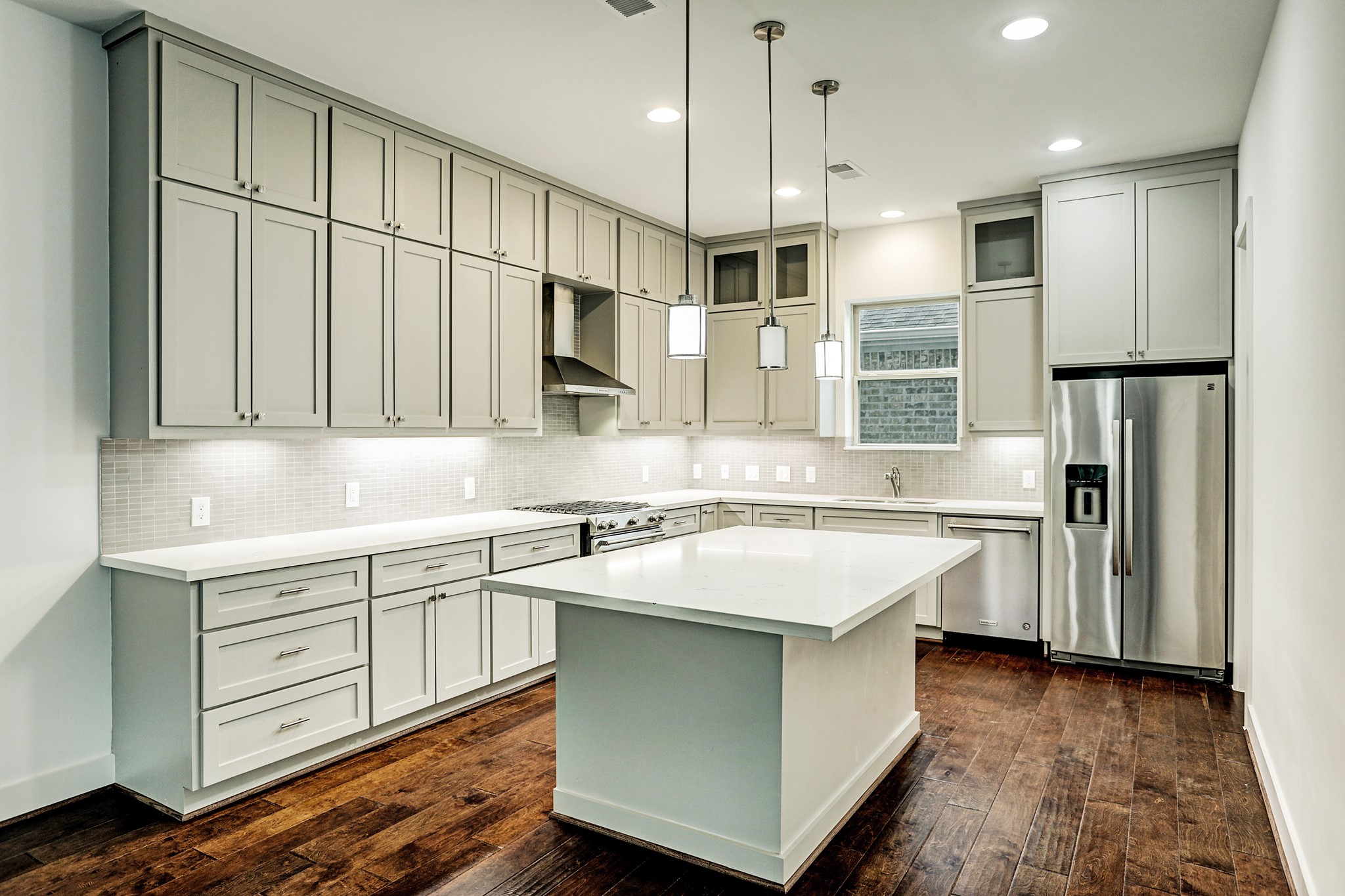 1402 Eberhard Street Houston, TX 77019 - Photo 27 of 50 a kitchen with stainless steel appliances granite countertop a sink a stove a refrigerator and island with wooden floor