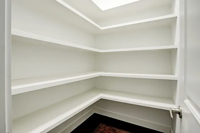 a view of a small space with wooden floor and a window