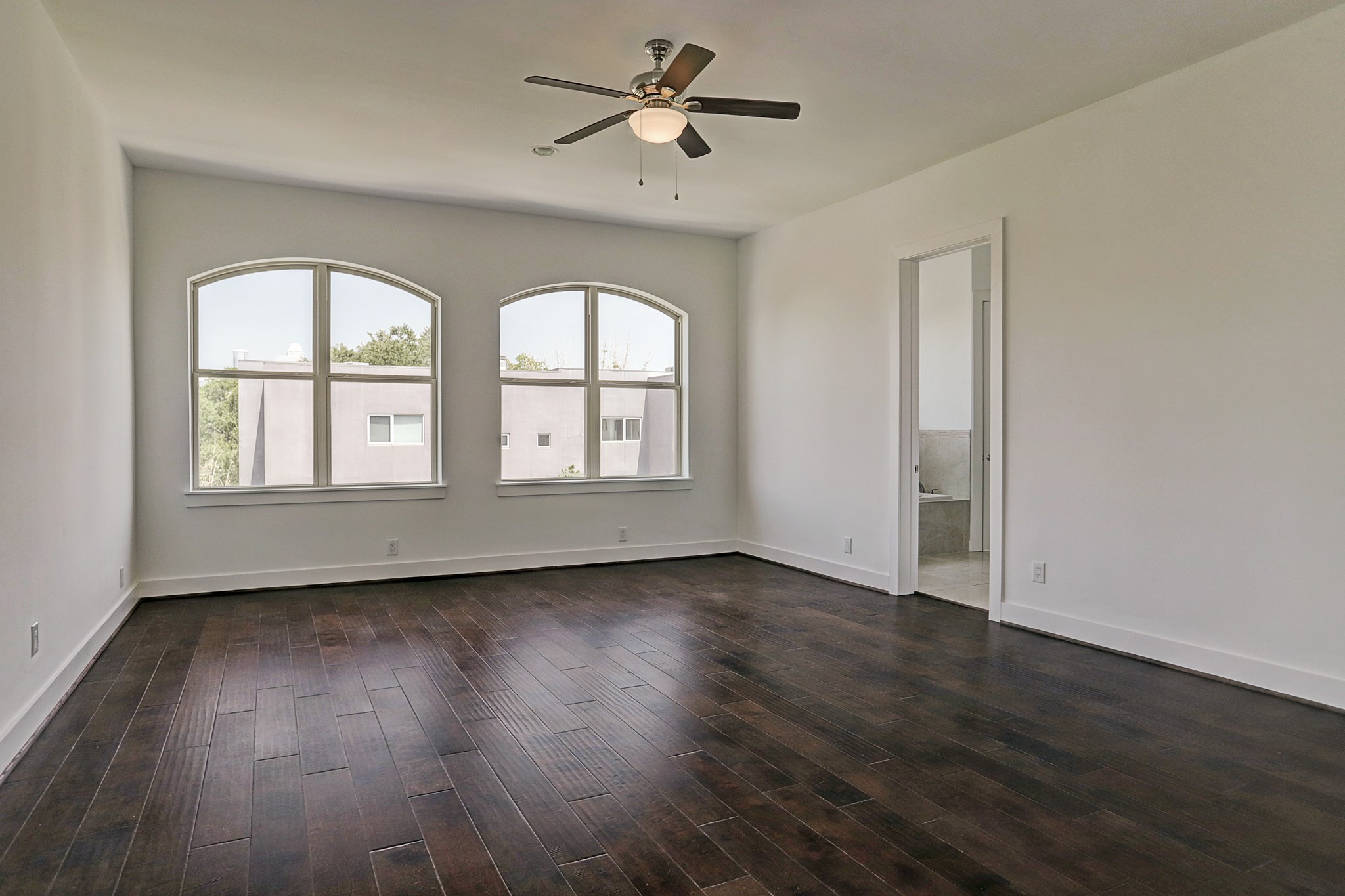 1402 Eberhard Street Houston, TX 77019 - Photo 32 of 50 an empty room with wooden floor chandelier fan and windows