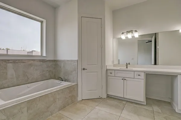 a spacious bathroom with a tub sink and mirror