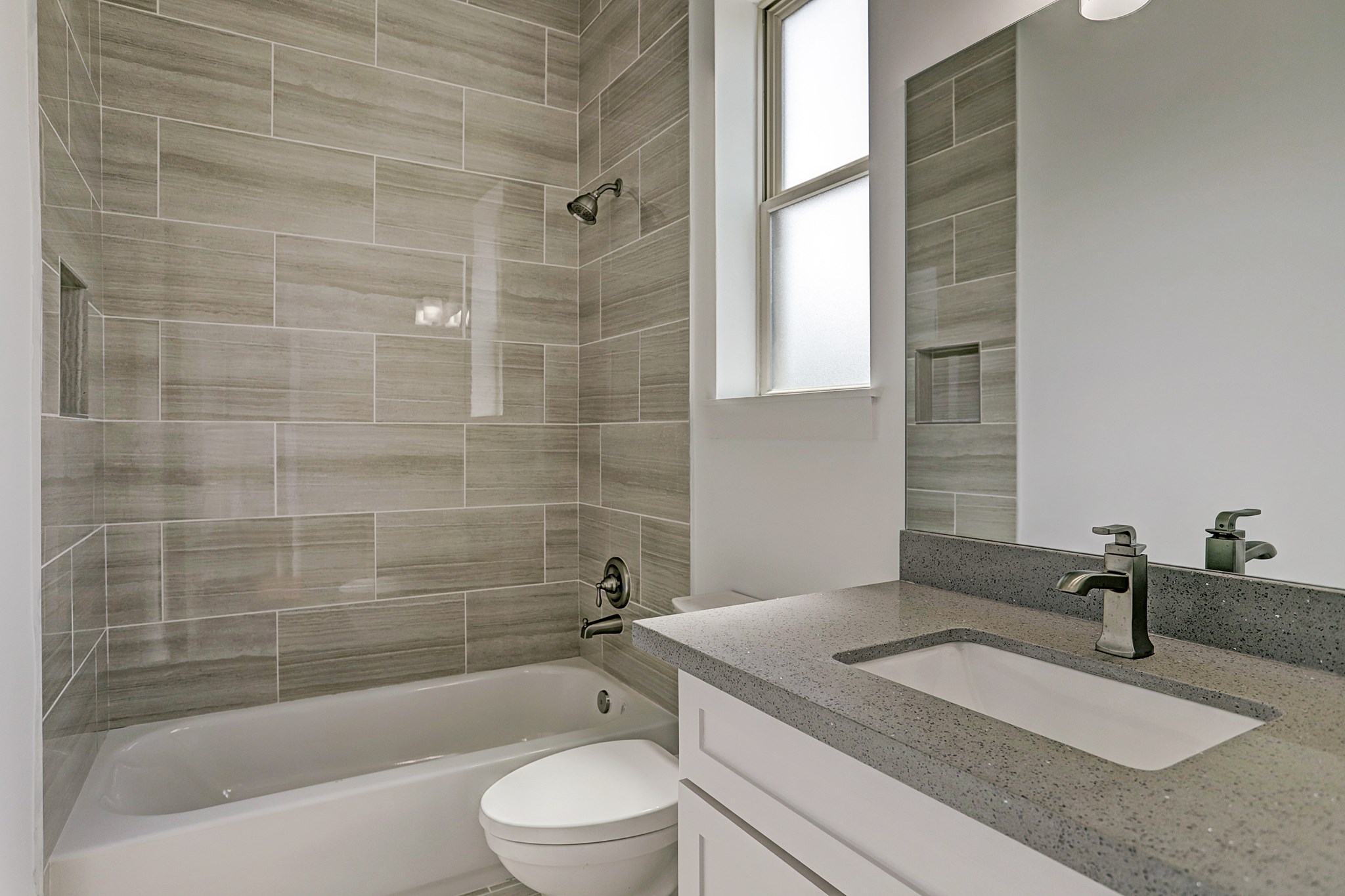 1402 Eberhard Street Houston, TX 77019 - Photo 39 of 50 a bathroom with a granite countertop sink a toilet a mirror and bathtub