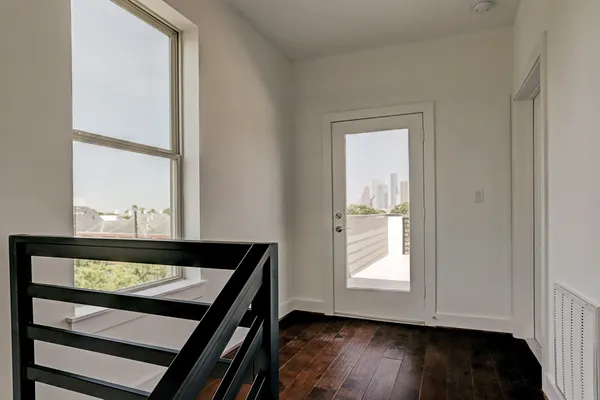 a view of a small space with wooden floor and a window