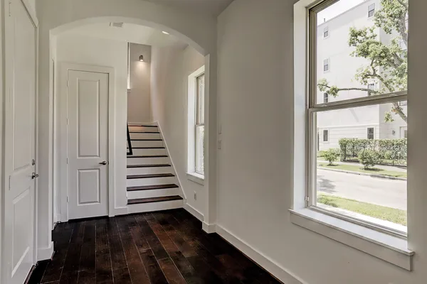 a view of a hallway with wooden floor and stairs