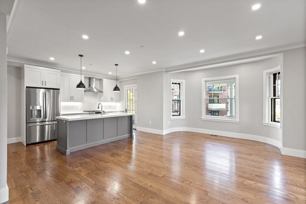 24 Selkirk Road, Unit 1 Boston, MA 02135 - Photo 7 of 30 a large kitchen with stainless steel appliances granite countertop a large counter top a sink and a refrigerator