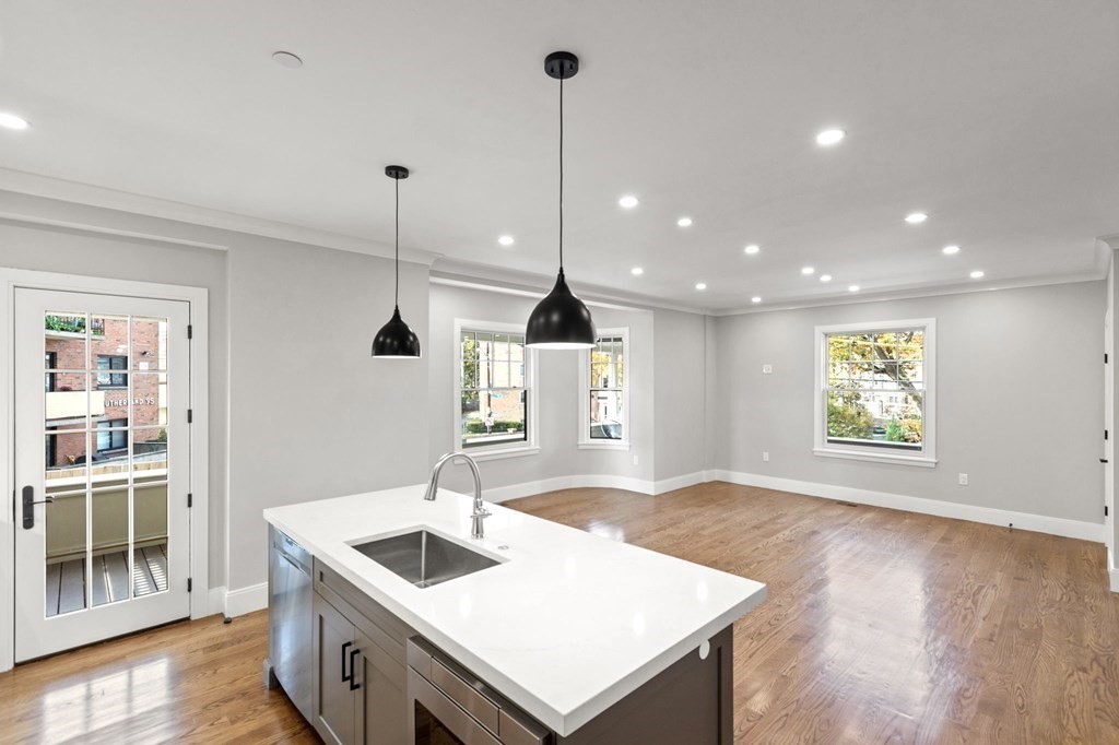 24 Selkirk Road, Unit 1 Boston, MA 02135 - Photo 8 of 30 a kitchen with a sink a faucet a stove and wooden floor