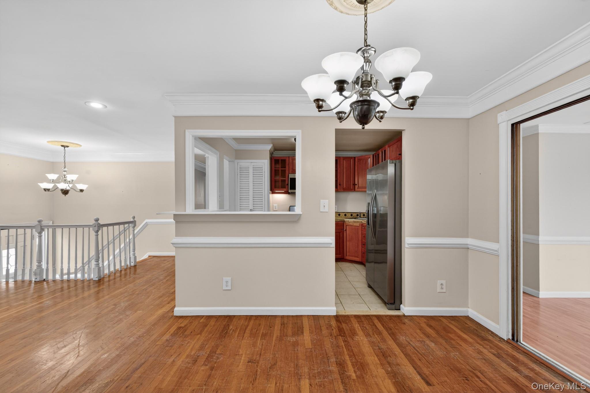 138 Spring Street Massapequa, NY 11758 - Photo 12 of 45 a view of a hallway with wooden floor and a chandelier