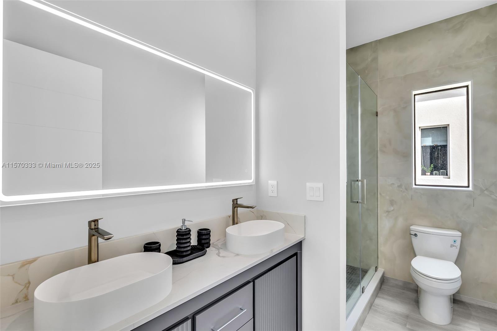 808 Southwest 9th Street, Unit 808A Fort Lauderdale, FL 33315 - Photo 25 of 30 a bathroom with a toilet a sink and mirror