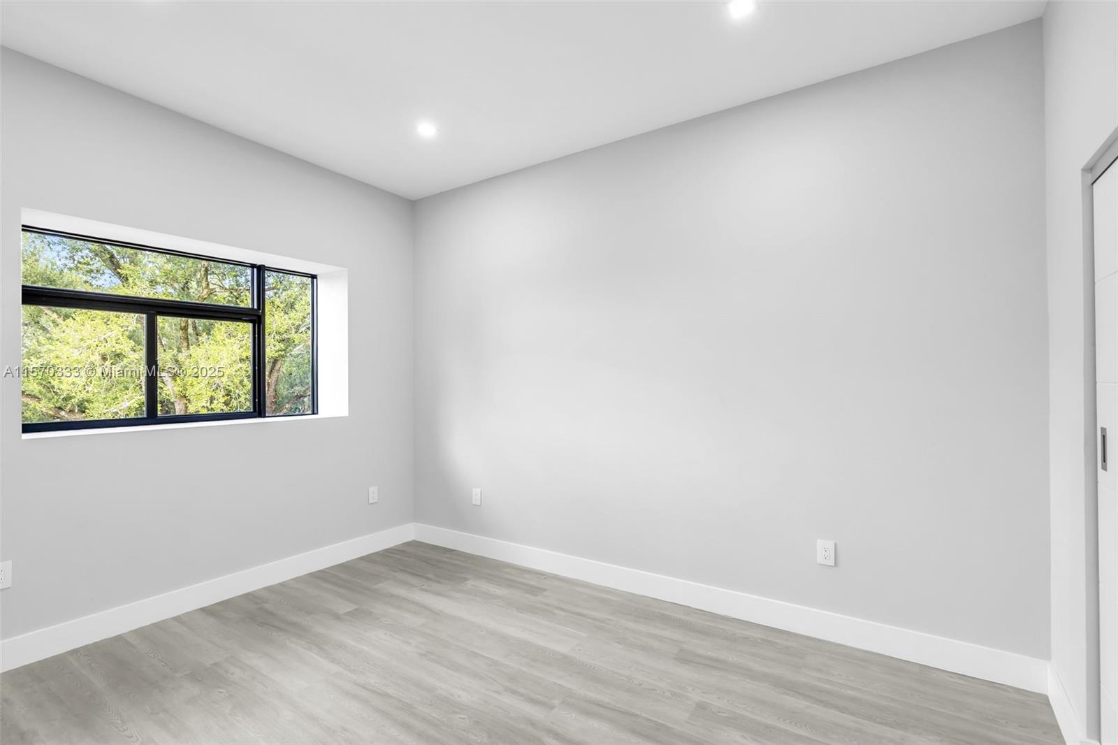 808 Southwest 9th Street, Unit 808A Fort Lauderdale, FL 33315 - Photo 27 of 30 an empty room with wooden floor and windows