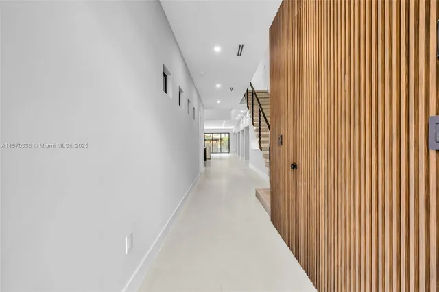 a view of a hallway with wooden floor and staircase