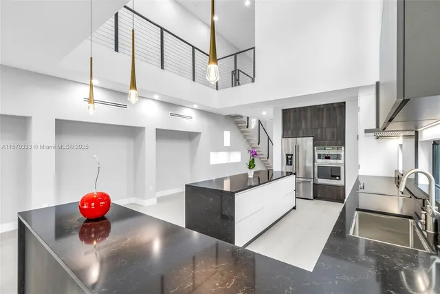 a living room with stainless steel appliances kitchen island furniture and a kitchen view