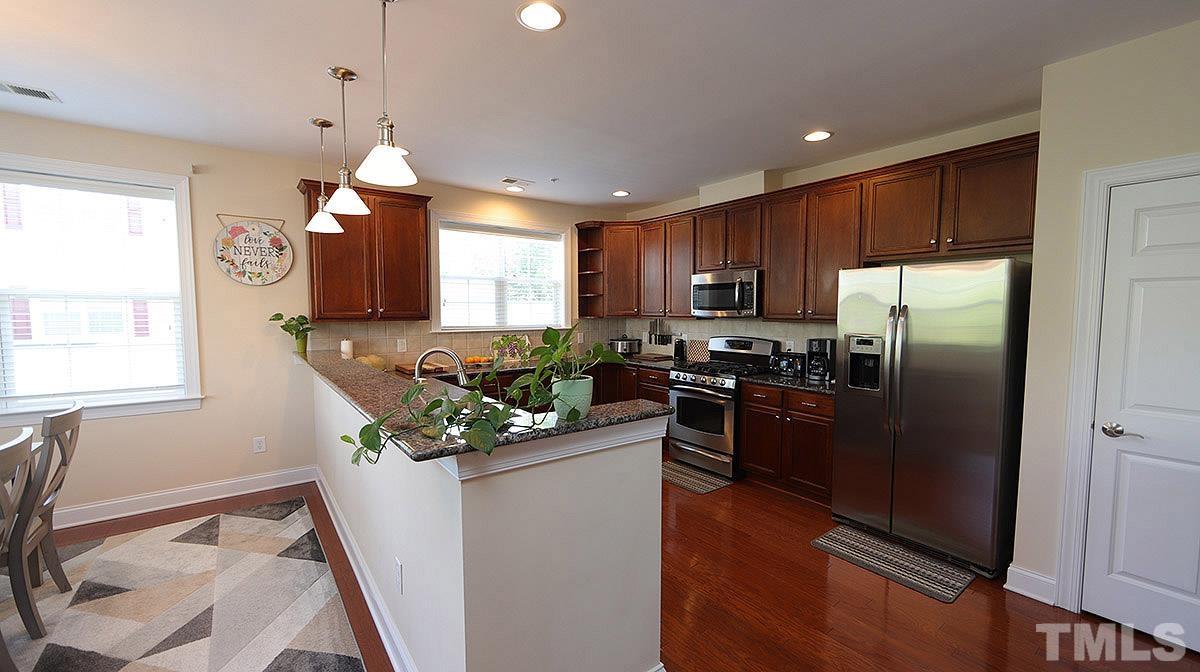 10411 Rosegate Court, Unit 202 Raleigh, NC 27617 - Photo 12 of 35 a kitchen with stainless steel appliances granite countertop a refrigerator a sink a stove a microwave a counter space and cabinets