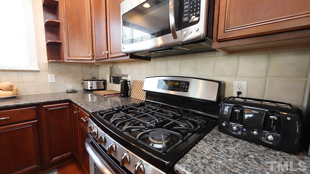 10411 Rosegate Court, Unit 202 Raleigh, NC 27617 - Photo 15 of 35 a kitchen with stainless steel appliances granite countertop a stove and a microwave