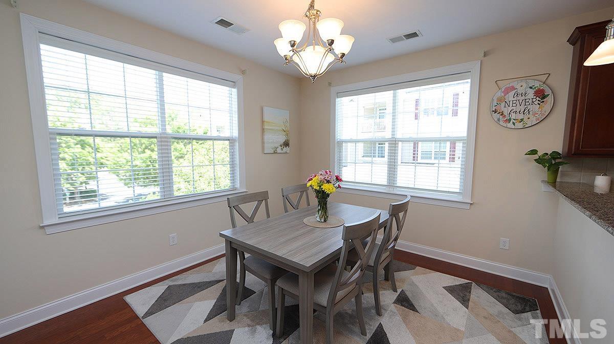 10411 Rosegate Court, Unit 202 Raleigh, NC 27617 - Photo 17 of 35 a dining room with chandelier and wooden floor