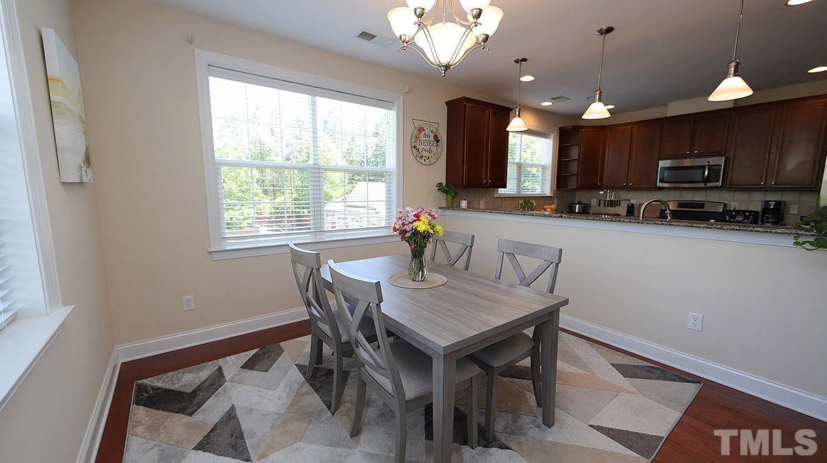 10411 Rosegate Court, Unit 202 Raleigh, NC 27617 - Photo 18 of 35 a kitchen with a dining table chairs and microwave
