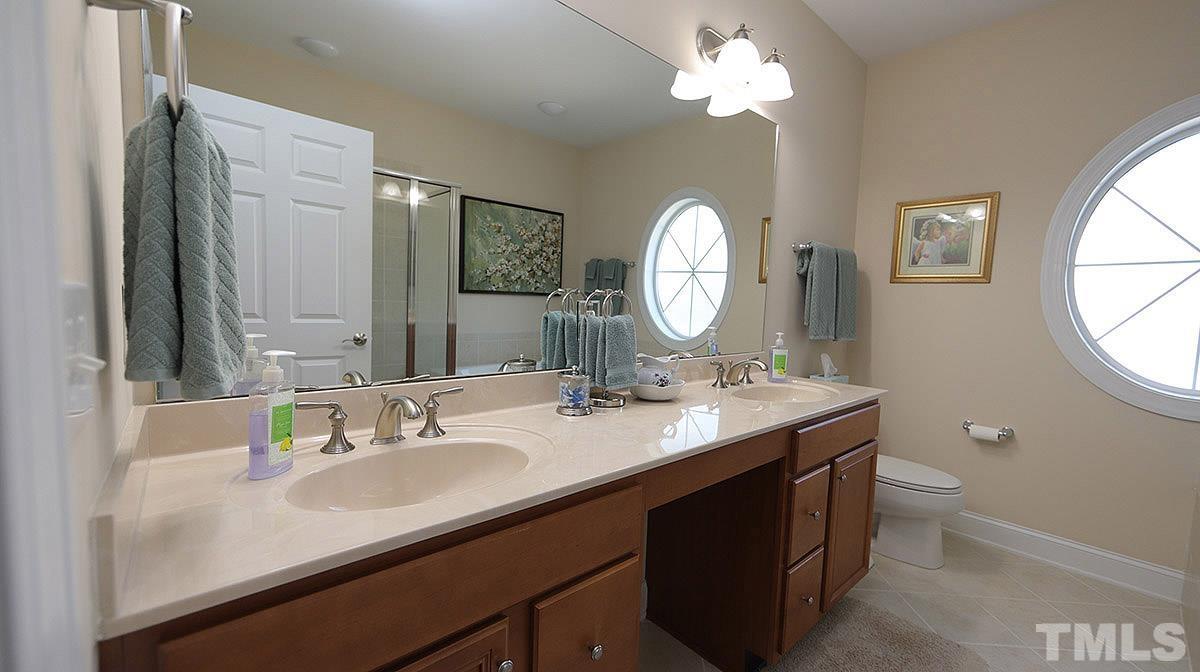 10411 Rosegate Court, Unit 202 Raleigh, NC 27617 - Photo 21 of 35 a bathroom with a double vanity sink and a mirror