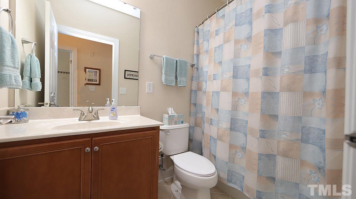 10411 Rosegate Court, Unit 202 Raleigh, NC 27617 - Photo 24 of 35 a bathroom with a granite countertop sink a toilet and a mirror