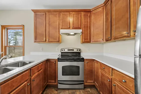 a kitchen with granite countertop a sink stove and cabinets