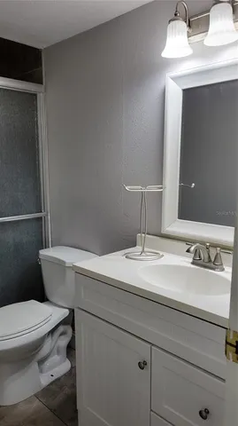 a bathroom with a sink a toilet a mirror and vanity