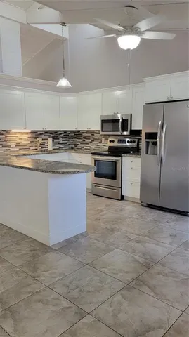 a kitchen with kitchen island granite countertop a stove a sink and a refrigerator