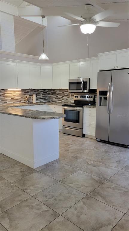500 North Jefferson Avenue, Unit E5 Sarasota, FL 34237 - Photo 4 of 22 a kitchen with kitchen island granite countertop a stove a sink and a refrigerator