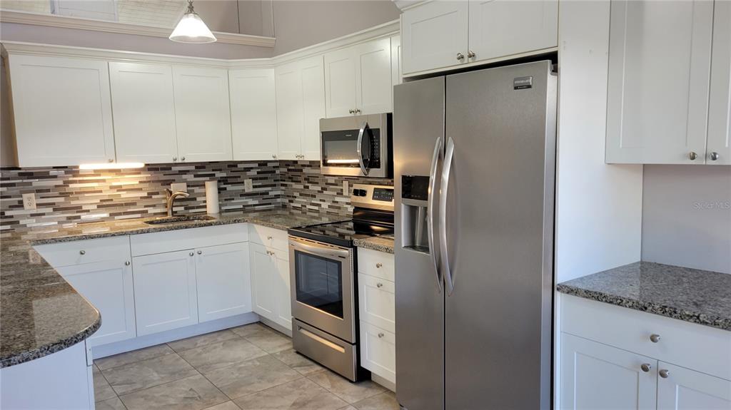 500 North Jefferson Avenue, Unit E5 Sarasota, FL 34237 - Photo 5 of 22 a kitchen with stainless steel appliances granite countertop a refrigerator and a stove