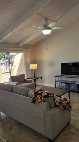 a living room with furniture a flat screen tv and a large window