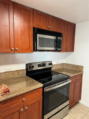 a kitchen with granite countertop a sink and a stove
