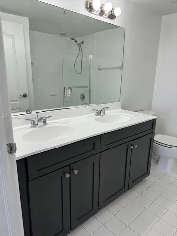 a bathroom with a sink vanity mirror and toilet