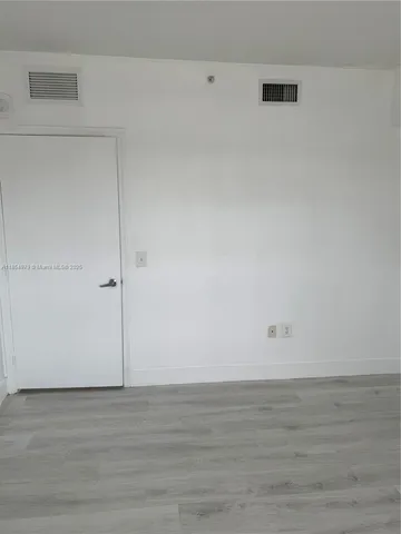 a view of a room with wooden floor and entryway