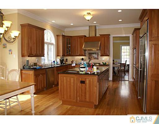16 Westley Road Old Bridge, NJ 08857 - Photo 3 of 25 a kitchen with stainless steel appliances kitchen island granite countertop a sink dishwasher a stove and a refrigerator with wooden floor