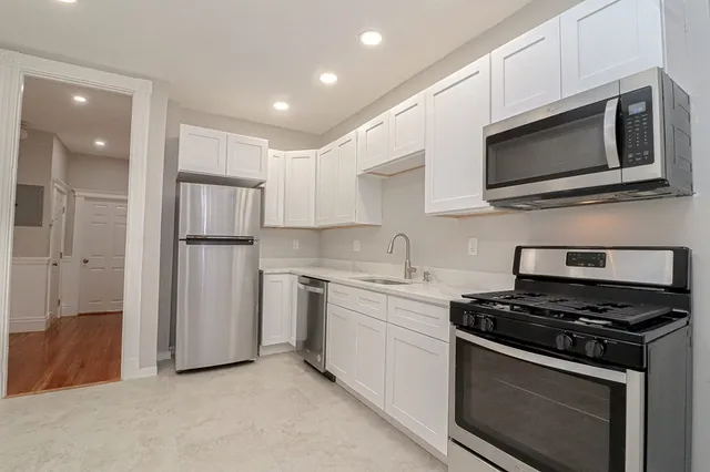 a kitchen with stainless steel appliances a stove microwave and sink