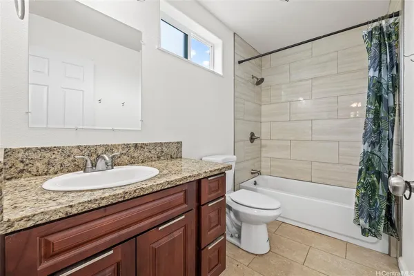 a bathroom with a granite countertop sink a toilet and shower
