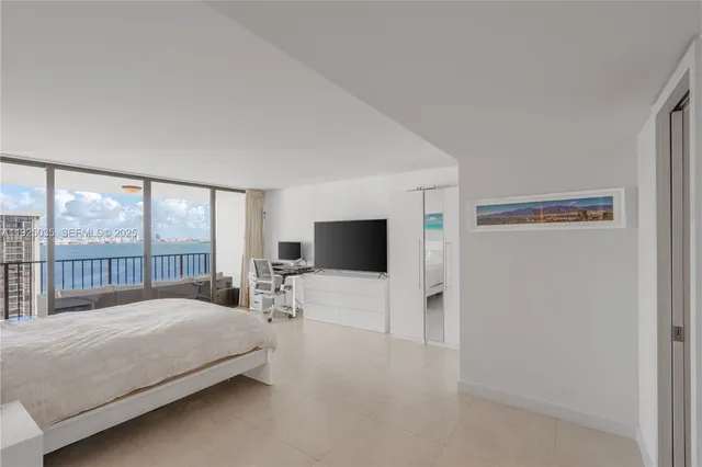 a large bedroom with a bed and large window