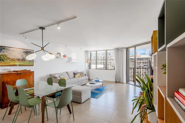 a living room with furniture a bookshelf and a chandelier