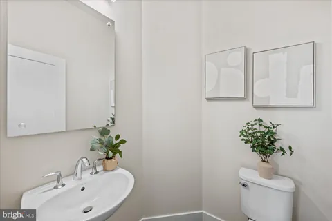 a bathroom with a sink a toilet and a mirror