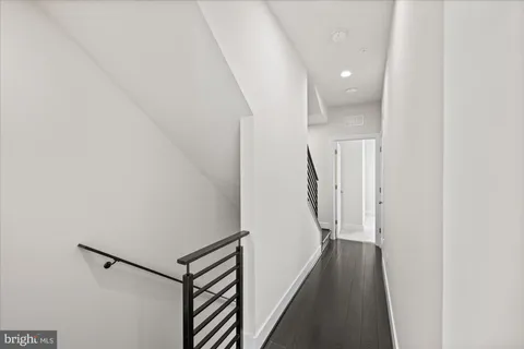 a view of a hallway with a white walls and stairs
