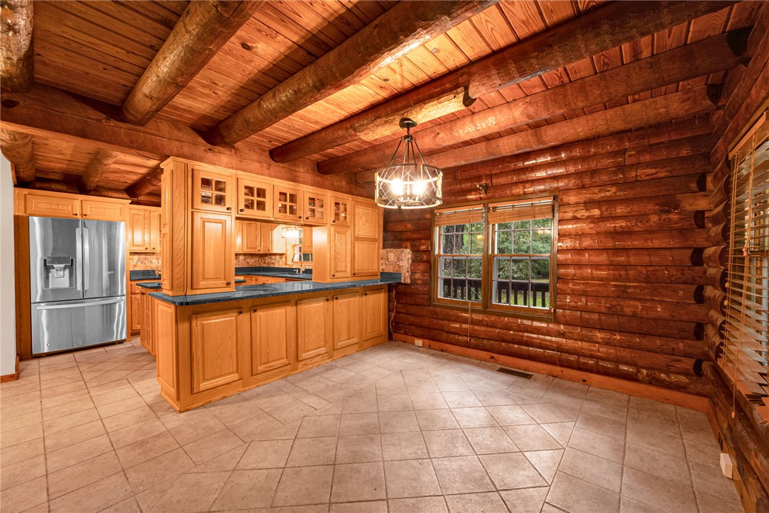 237 Spring Valley Road Liberty, SC 29657 - Photo 12 of 50 A spacious kitchen with natural wood walls and ceiling beams exudes rustic charm.