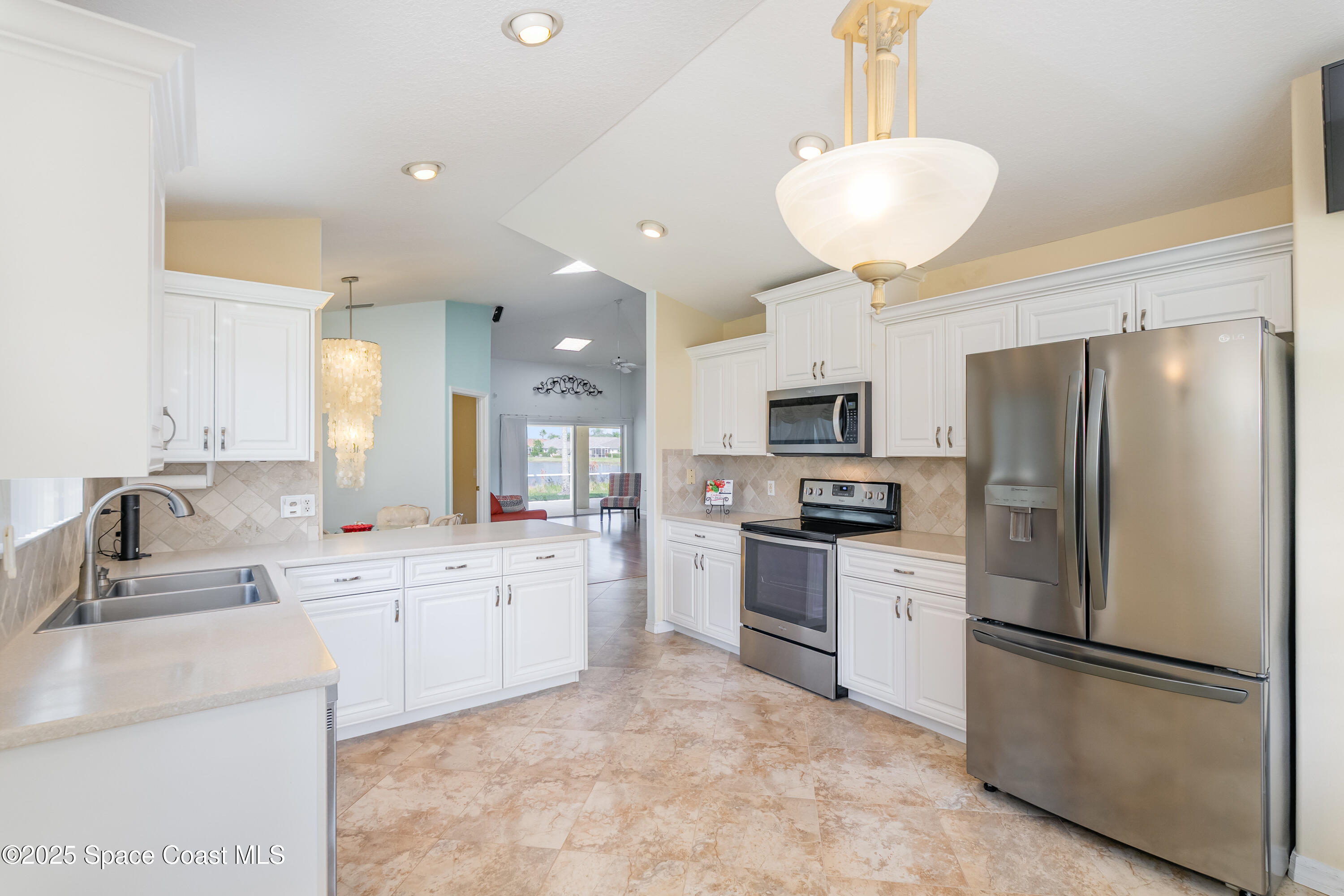 1664 Boca Rio Drive Melbourne, FL 32940 - Photo 11 of 46 a large kitchen with stainless steel appliances granite countertop a refrigerator sink and cabinets
