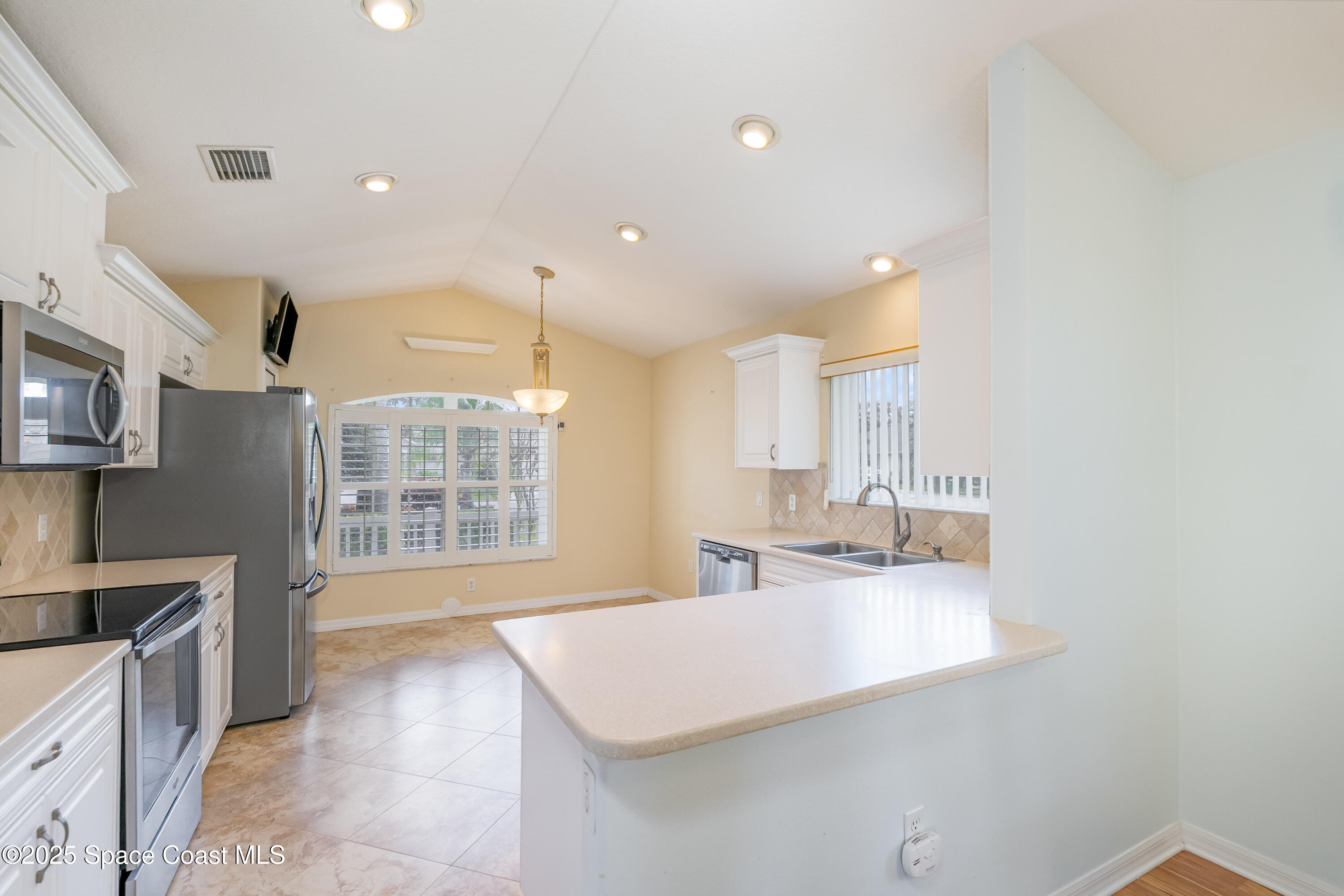 1664 Boca Rio Drive Melbourne, FL 32940 - Photo 12 of 46 a large kitchen with kitchen island a sink stainless steel appliances and cabinets