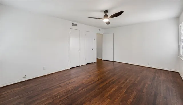a view of a room with wooden floor and ceiling fan