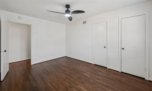 a view of an empty room with wooden floor
