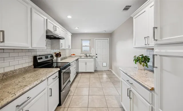 a kitchen with a sink stove and cabinets