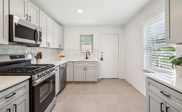 a kitchen with a stove a sink and a microwave