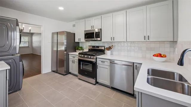 a kitchen with stainless steel appliances granite countertop a refrigerator sink and stove